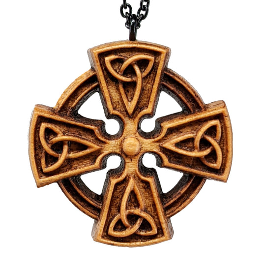 Wooden necklace pendant created in the shape of a Celtic cross. Made from hard maple wood and hanging from a black stainless steel chain against a white background.