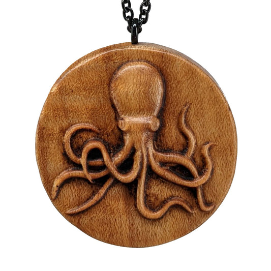 Wooden pendant necklace carved in the shape of a octopus. Made from hard maple wood and hanging from a black stainless steel chain against a white background.