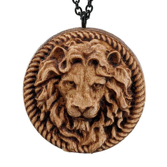 Wooden necklace pendant carved in the shape of a stern lion face surrounded by a rope border. Hanging from a black stainless steel chain against a white background.