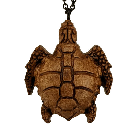 Wooden necklace pendant carved in the shape of a sea turtle. Made from hard maple wood. Hanging from a black stainless steel chain against a white background.