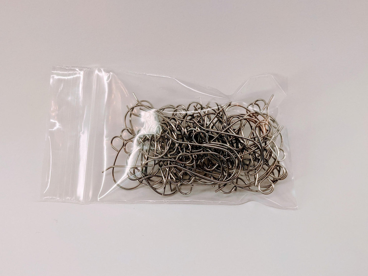 30 pairs of 316L stainless steel earring hooks in a clear plastic bag with an enclosed top.