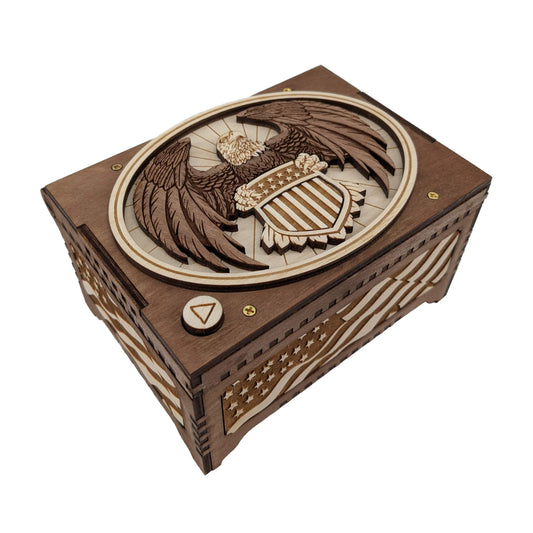 Patriotic music box brown in color, engraved with an American Flag and a bald eagle clutching a stars and stripes shield.