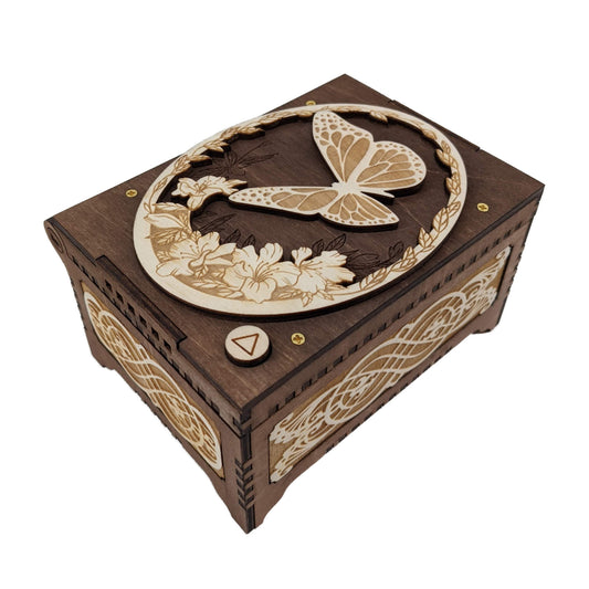 Butterfly music box, dark brown and birch wood in color, with decorative floral filigree patterns engraved on the sides.