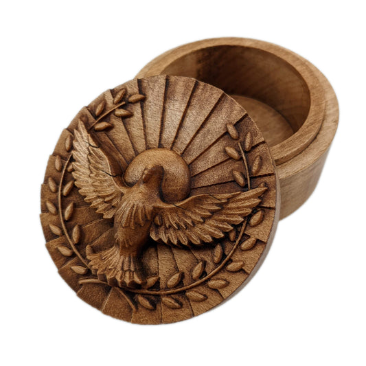 Round wooden box 3D carved with a dove partially eclipsing a sun with rays shooting out, facing forward layered feathered wings spread wide and two olive branches around the wings. Made from hard maple wood stained brown against a white background.