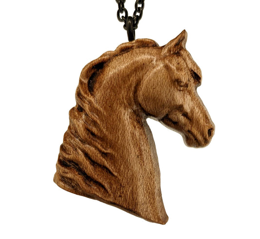 Wooden pendant realistically carved in the shape of a horse. Made form hard maple and hung from a black stainless steel chain against a white background.