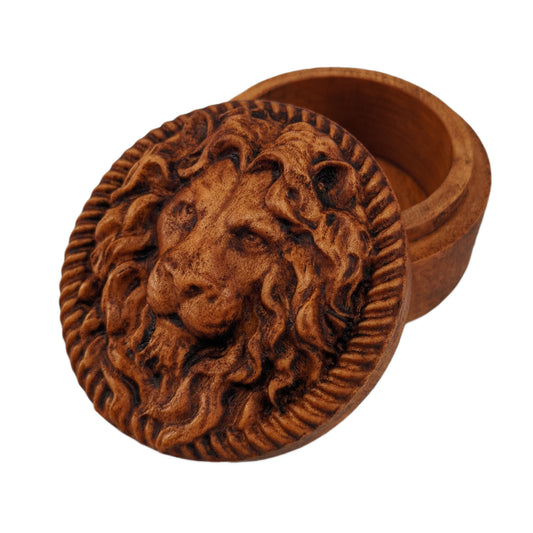 Round wooden box 3D carved with a lions face looking straight ahead surrounded by a rope border. With stern look in its eyes with its mane parted in the middle draping over its face. Made from hard maple wood stained brown against a white background.