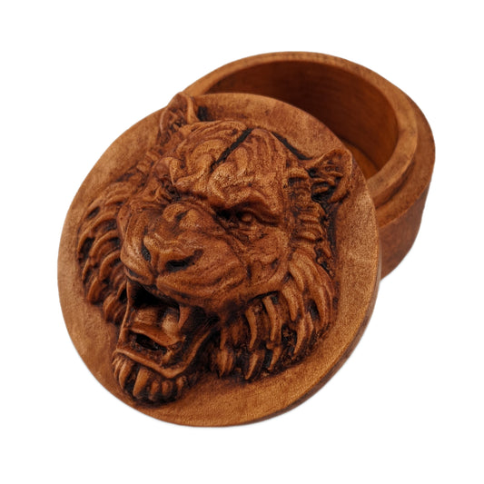 Round wooden box 3D carved with a tigers face looking straight ahead scowling and and showing its large fangs. It has burly fur on the sides of its face and chin. Made from hard maple wood stained brown against a white background.