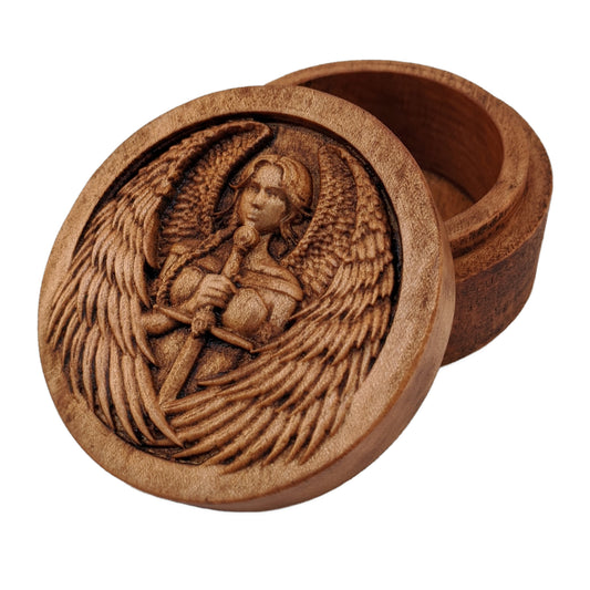 Round wooden box 3D carved with a warrior angel with a serious face and a sword straight down in front. She has parted bangs and large intricately layered wings with sharp tips. Made from hard maple wood stained brown against a white background.