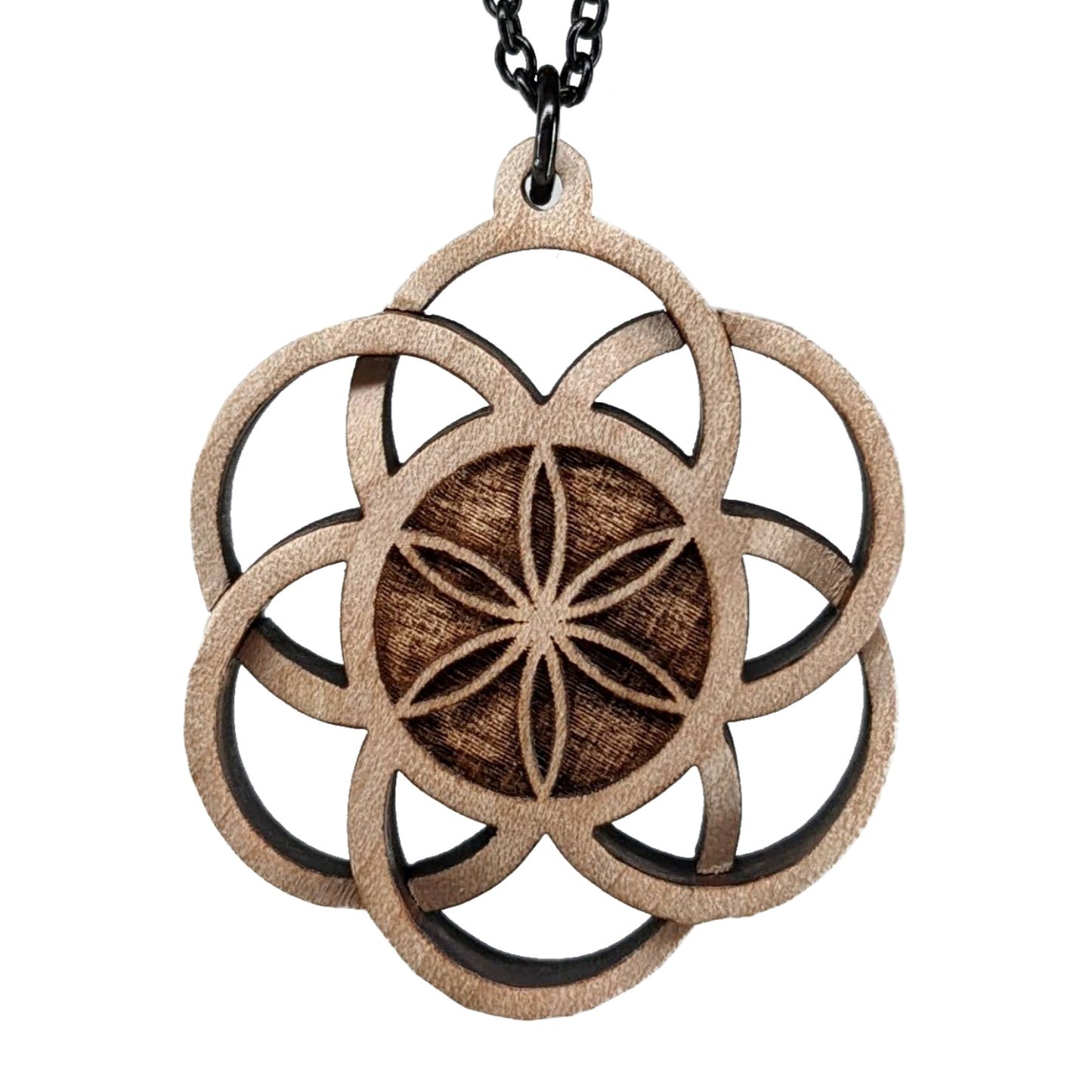 Wooden necklace pendant inspired by a flower of life including 6 interlinking circles creating a flower in the center. Carved from hard maple wood. Hanging from a black stainless steel chain against a white background.