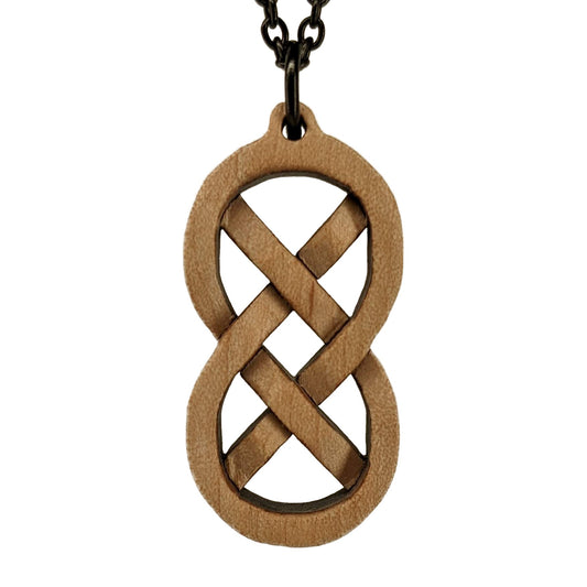 Wooden necklace pendant inspired by a Celtic weave. Carved from hard maple wood. Hanging from a black stainless steel chain against a white background.