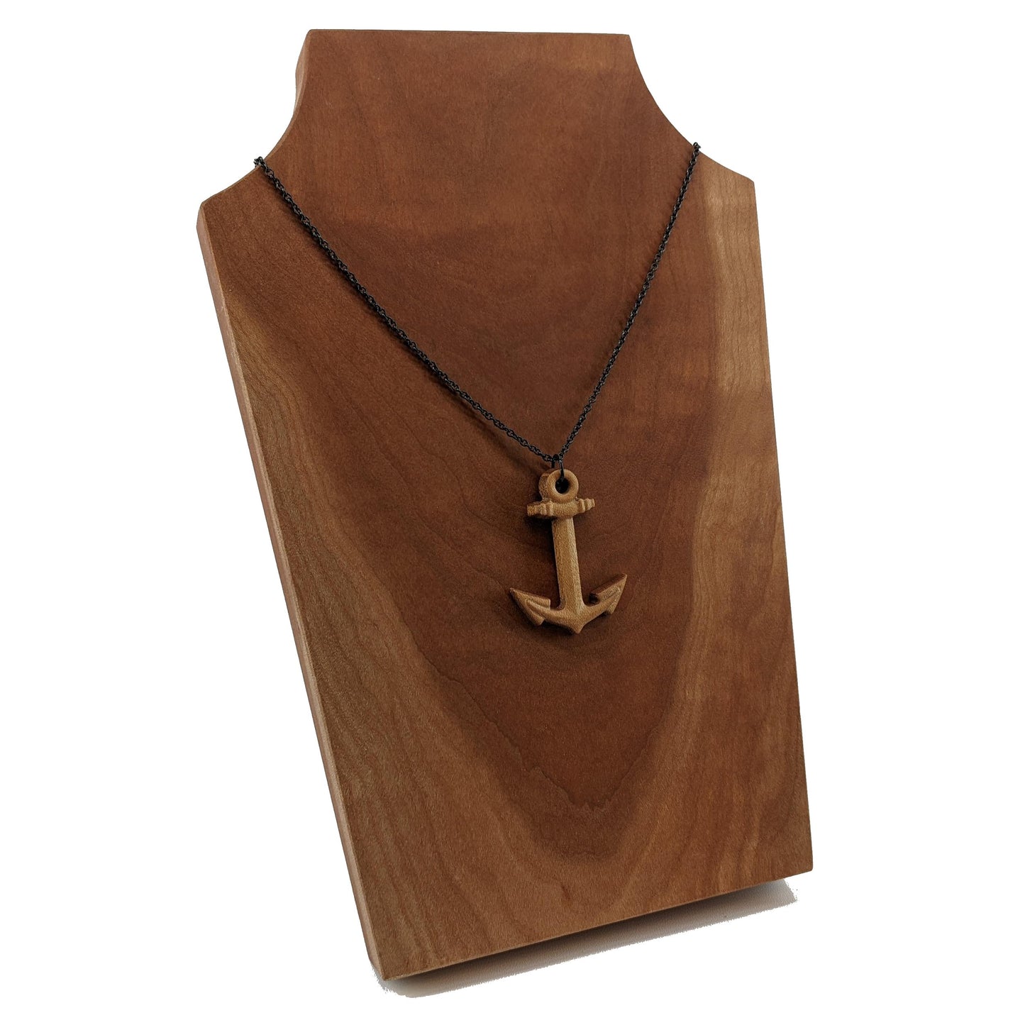 Wooden pendant necklace carved in the shape of a anchor. Made from hard maple wood. It hangs from a black stainless steel chain against a cherry wood display.