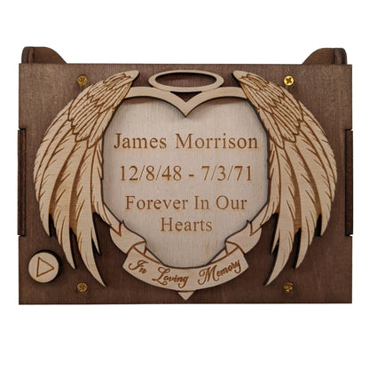 Engraved angel wings and halo surrounding a light wood engraved heart, with the words, James Morrison, 12/8/48-7/3/71, Forever in Our Hearts, In Loving Memory, engraved as an example on the top lid. 