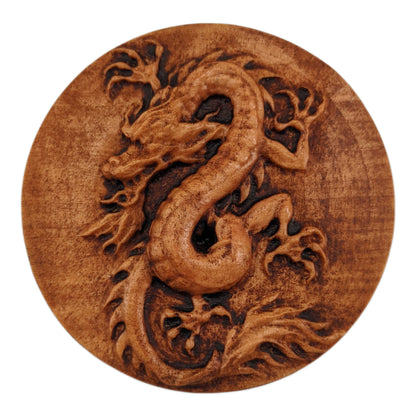 Round wooden box 3D carved with a Chinese dragon coiled around into an upright position. It has an angry bearded face, scaled underbelly, sharp claws, and spines down its back. Made from hard maple wood with a brown stain against a white background.