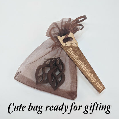 Brown shear gift bag filled with example pair of earrings with a wooden business card shaped like a saw that reads DavidsonWorkshop.com, all against a white background.