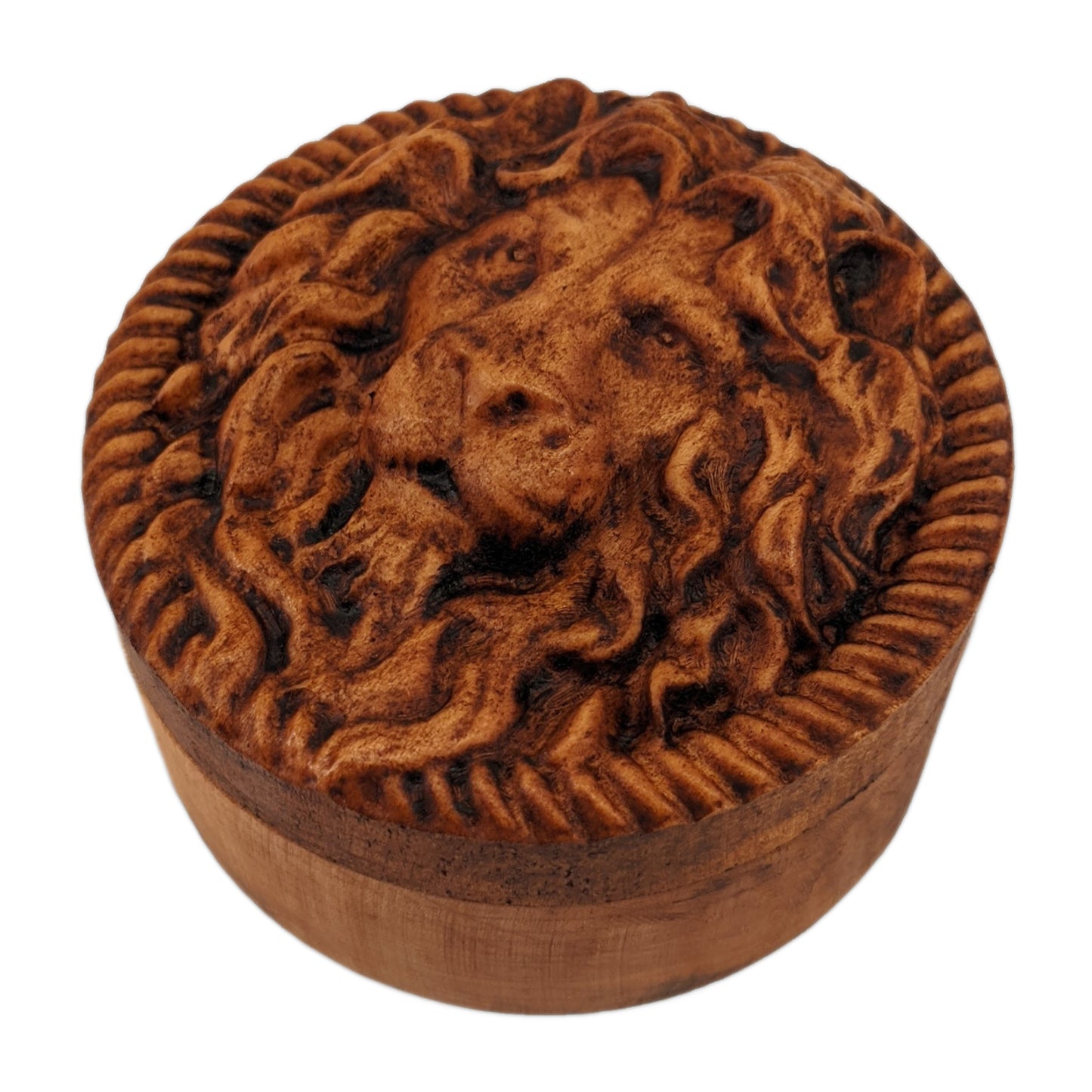 Round wooden box 3D carved with a lions face looking straight ahead surrounded by a rope border. With stern look in its eyes with its mane parted in the middle draping over its face. Made from hard maple wood stained brown against a white background.