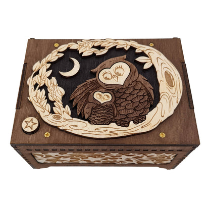 Top angled front view of the any song owl music box, showing the star engraved play button and the star themed decorative panel on the front of the box.