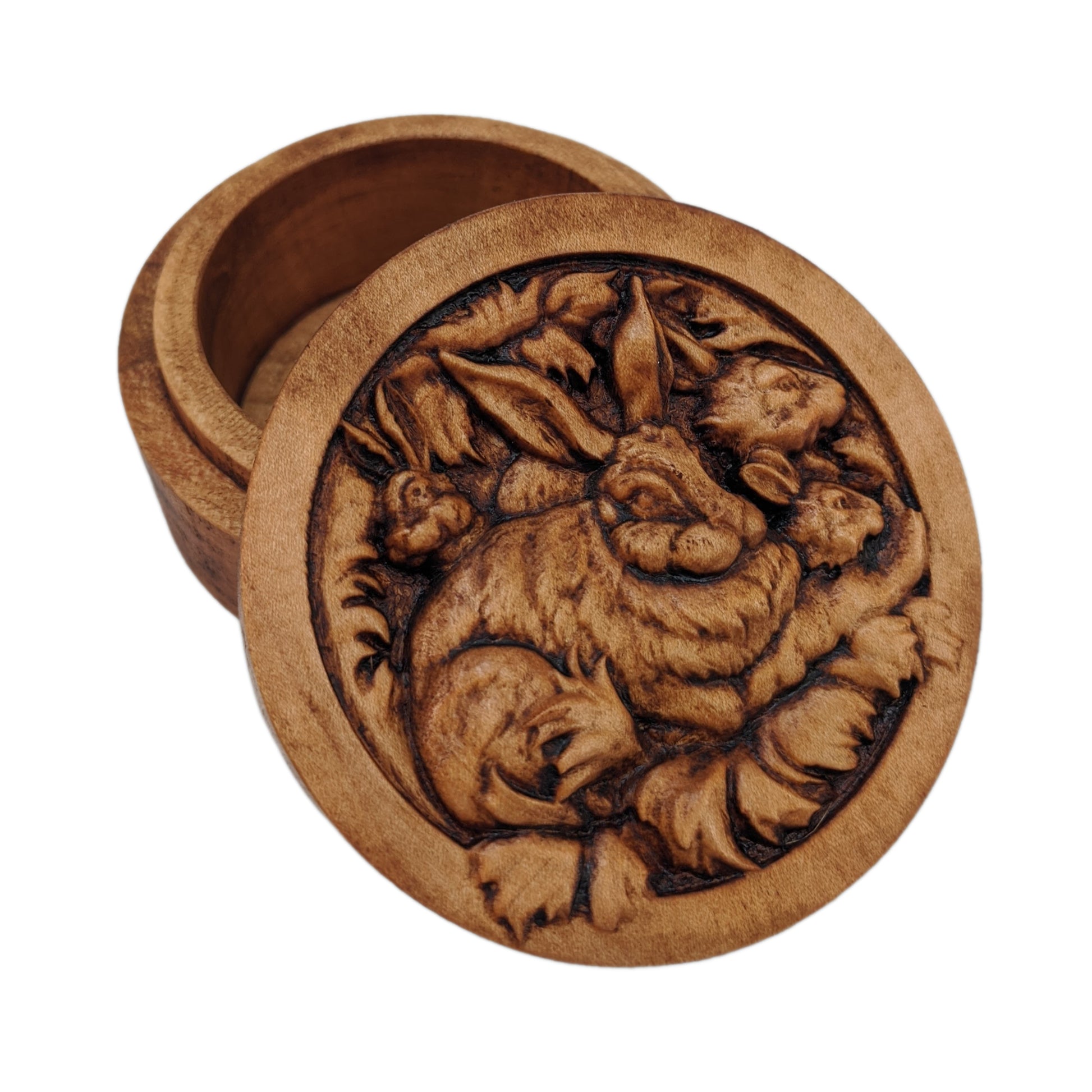 Round wooden box 3D carved with a family of rabbits together in their nest. Mother rabbit has bushy fur, tall ears and  heads of three baby rabbits peaking out from behind her. Made from hard maple wood stained brown against a white background.