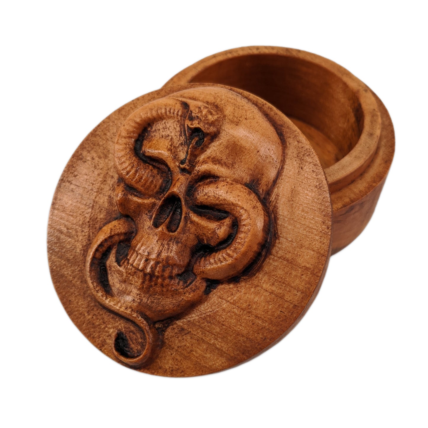 Round wooden box 3D carved with a Large skull facing forward with a snake intertwined through its jaw bone and eye sockets. The snake is looking forward hissing with its tongue out. Made from hard maple wood stained brown against a white background.