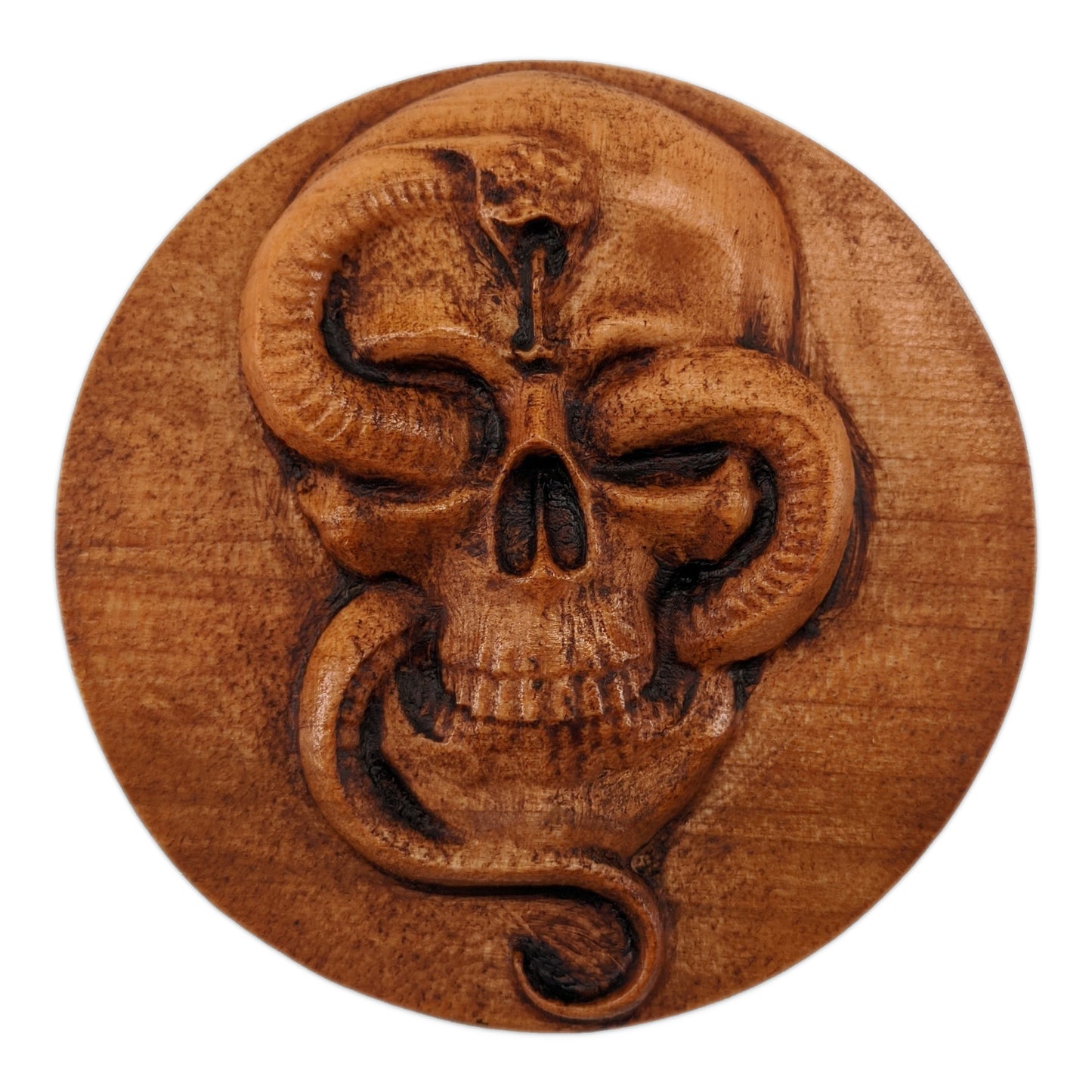 Round wooden box 3D carved with a Large skull facing forward with a snake intertwined through its jaw bone and eye sockets. The snake is looking forward hissing with its tongue out. Made from hard maple wood stained brown against a white background.