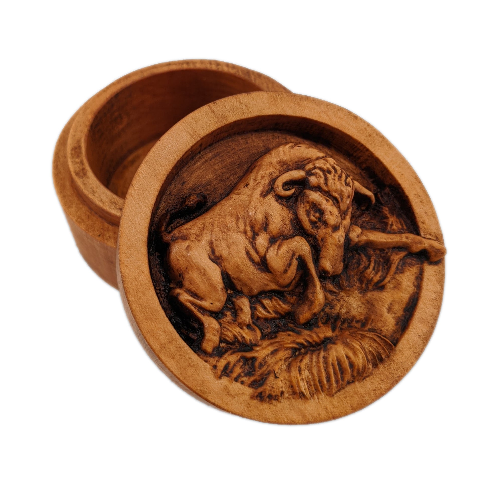 Round wooden box 3D carved with a angry bull charging forward stomping over small grassy patches on the ground. Its head is angled downward with its curved horns pointed ahead. Made from hard maple wood stained brown against a white background.