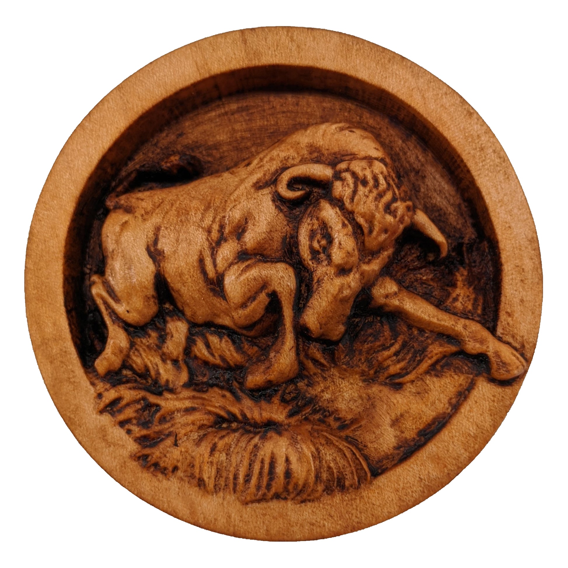 Round wooden box 3D carved with a angry bull charging forward stomping over small grassy patches on the ground. Its head is angled downward with its curved horns pointed ahead. Made from hard maple wood stained brown against a white background.