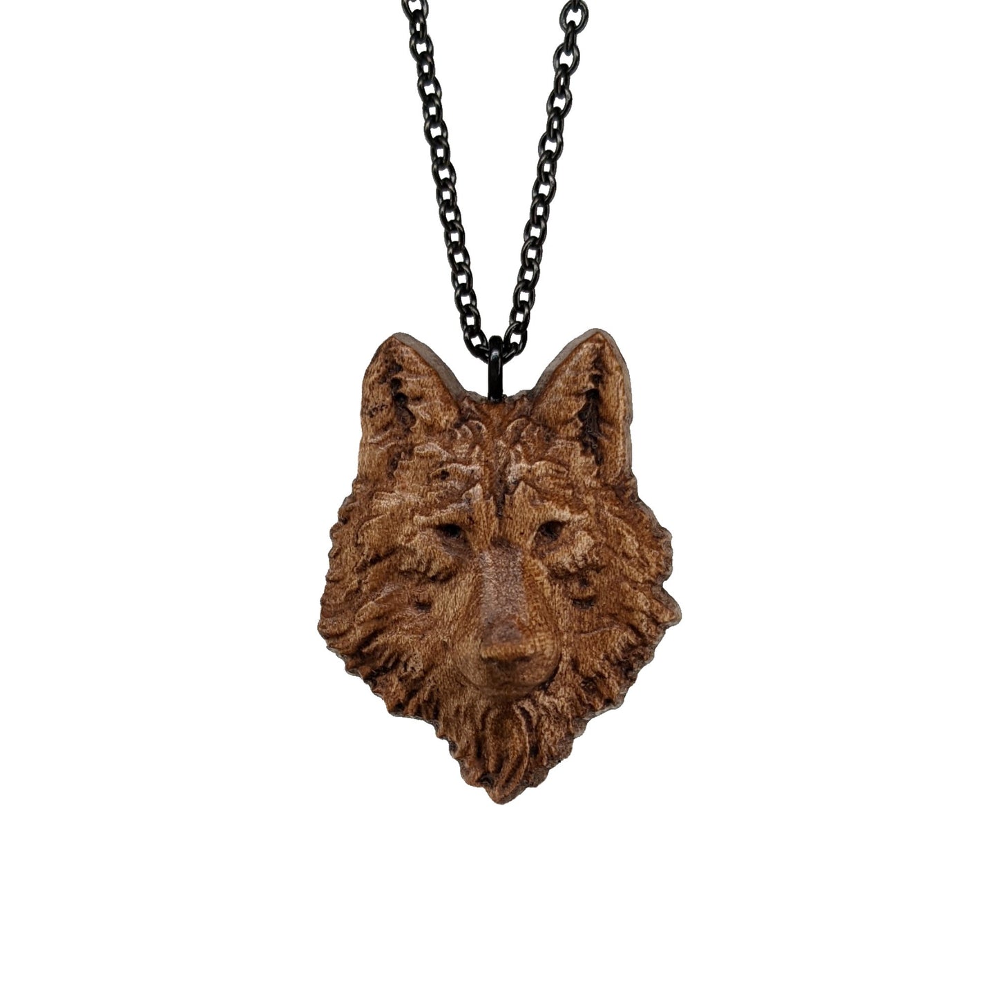 Wooden necklace pendant carved in the shaped of an wolf head. Made from hard maple wood. Hanging from a black stainless steel chain against a white background.